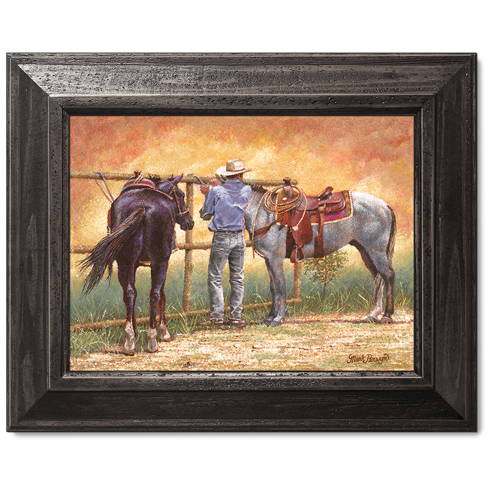 canvas print in a black wood frame depicting a cowboy standing
between two horses while a dust devil dances around them