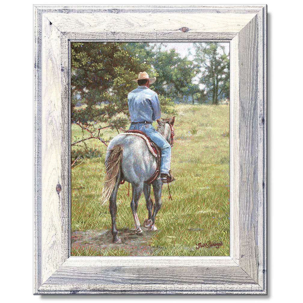 canvas print in a white wood frame depicting a cowboy riding
away on a grey horse