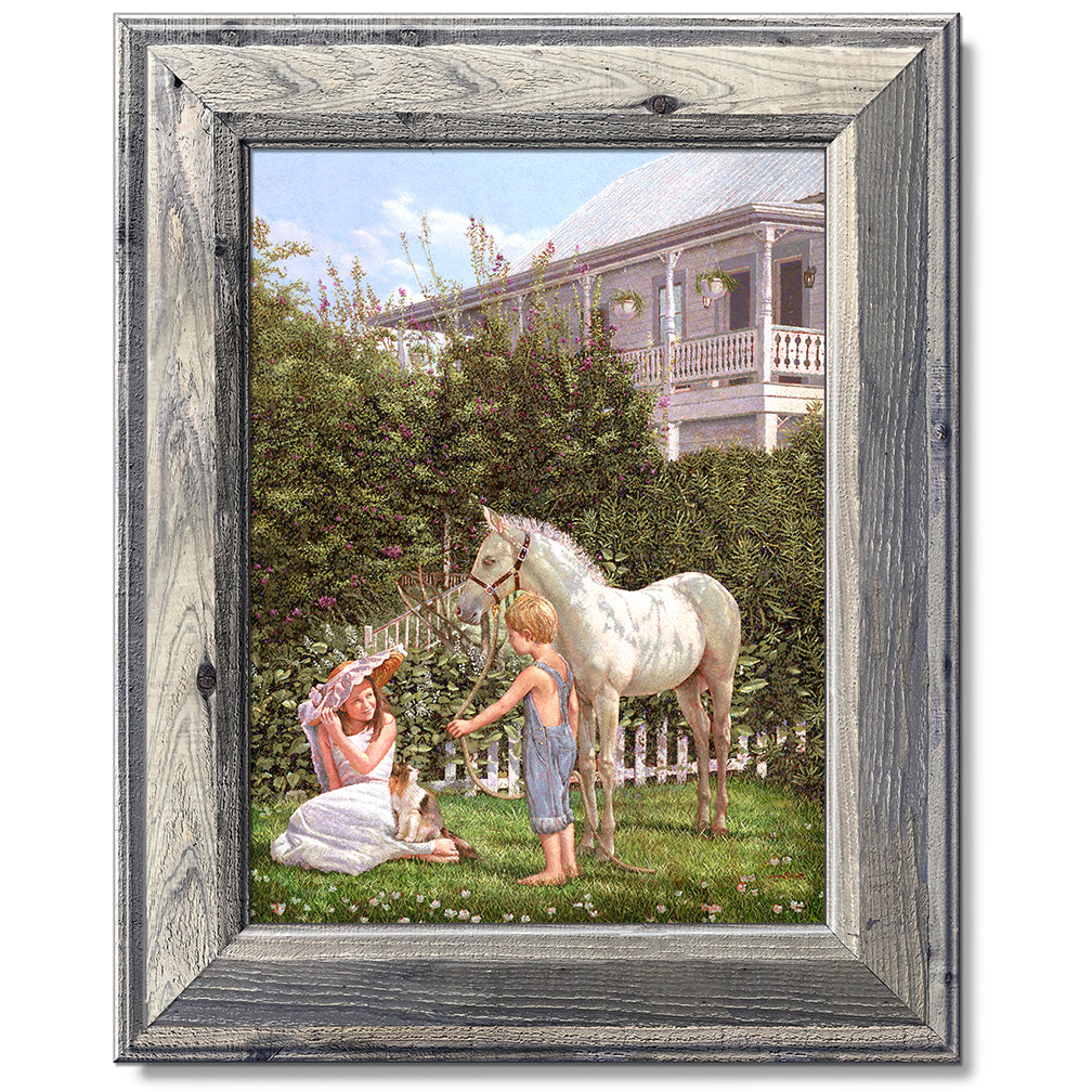 canvas print in a grey wood frame depicting children and a pony
with floral vegetation and a victorian house in the background