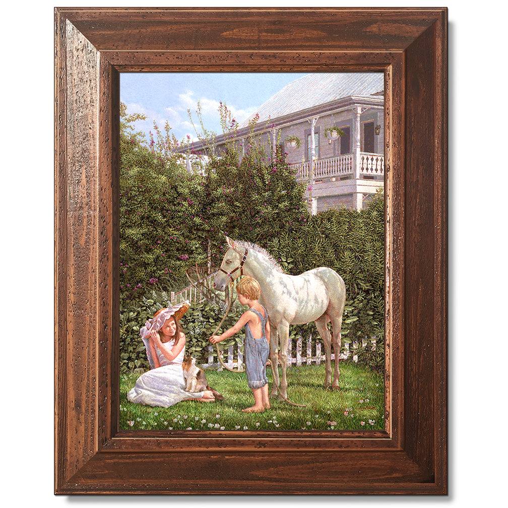 canvas print in a brown wood frame depicting children and a pony
with floral vegetation and a victorian house in the background