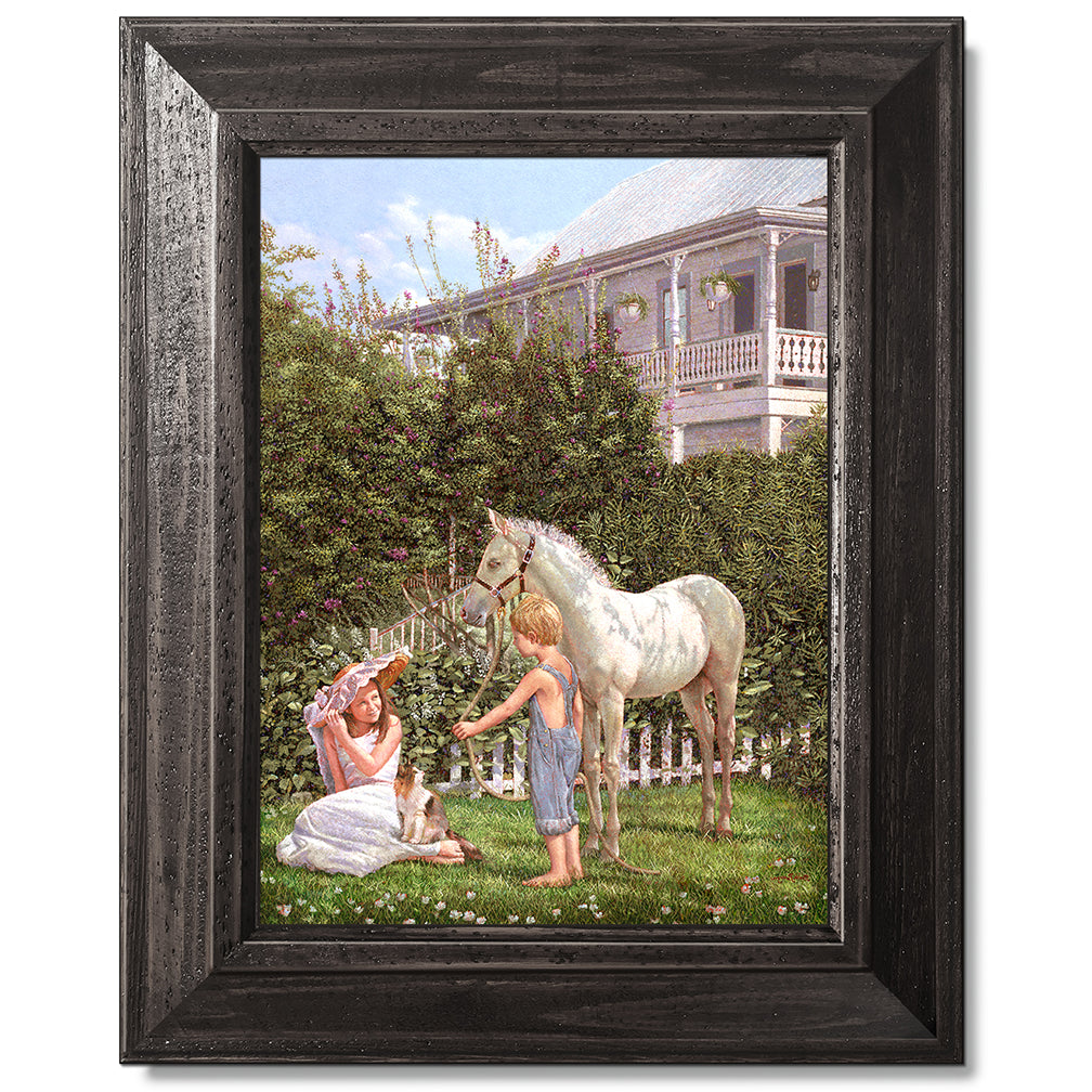 canvas print in a black wood frame depicting children and a pony
with floral vegetation and a victorian house in the background