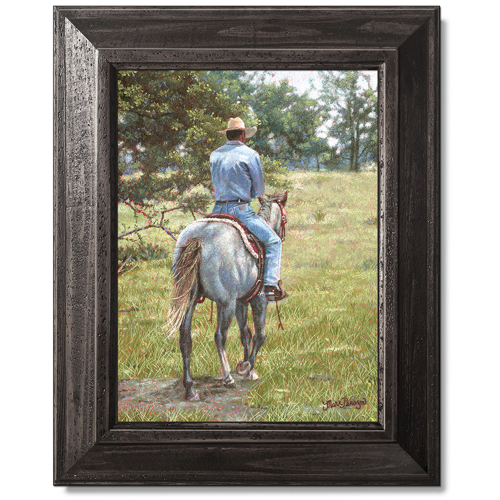 canvas print in a black wood frame depicting a cowboy riding
away on a grey horse 