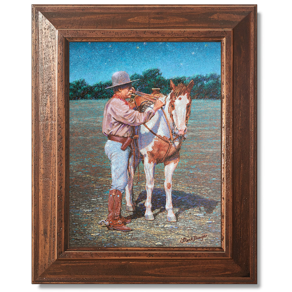 canvas print in a brown wood frame depicting a cowboy standing
beside his paint horse saddling it under a twilight sky