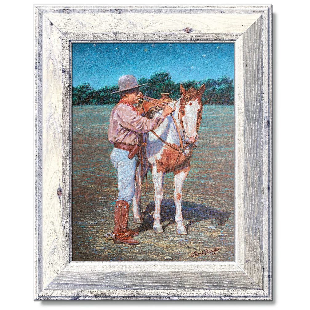 canvas print in a white wood frame depicting a cowboy standing
beside his paint horse saddling it under a twilight sky