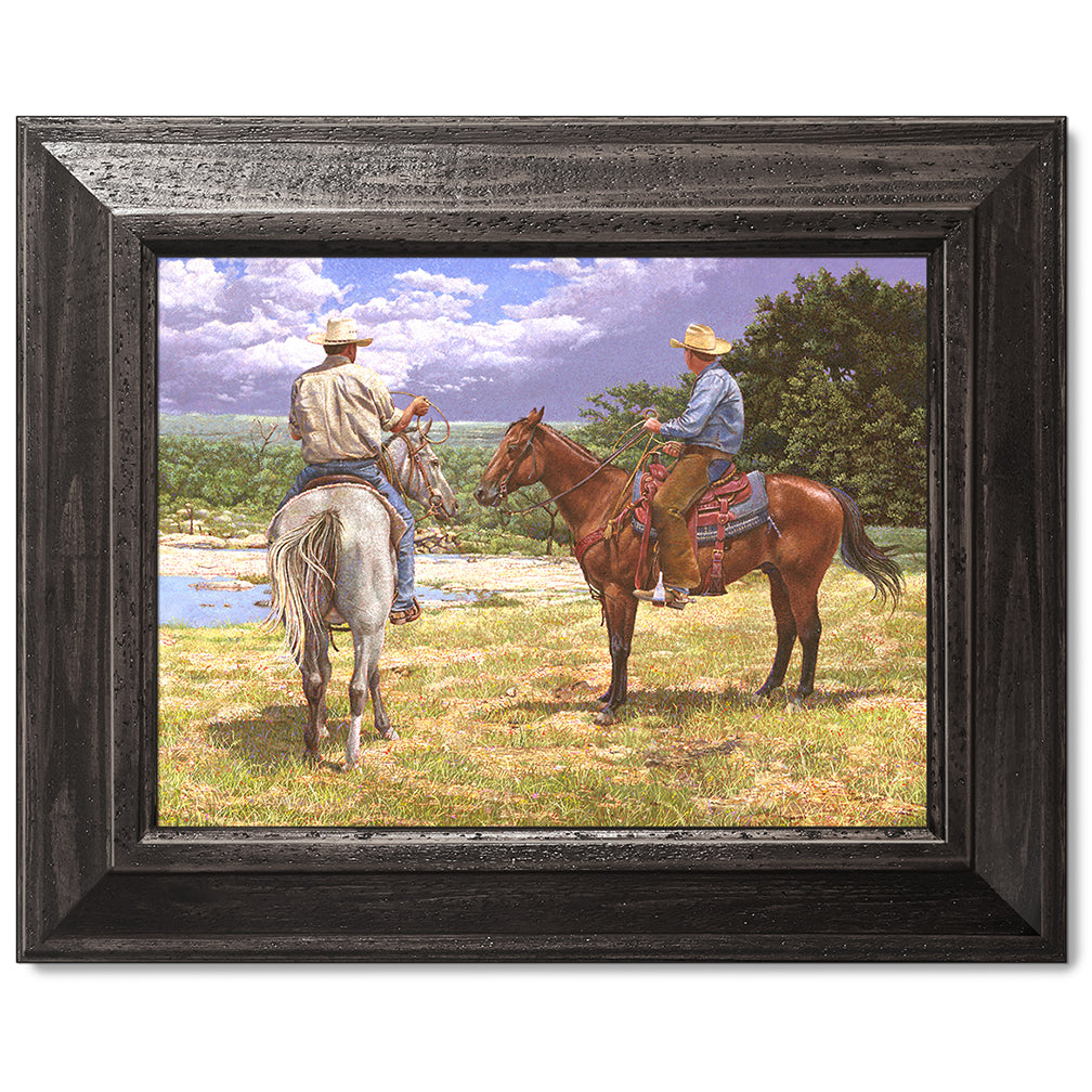 canvas print in a black wood frame depicting a country landscape
with two cowboys on horseback watching a thunderstorm