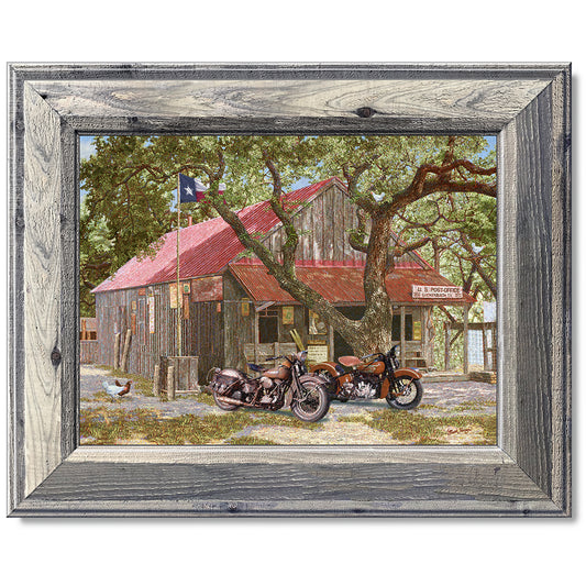 canvas print in a grey wood frame depicting classic motorcycles
parked in front of the luckenbach, texas post office